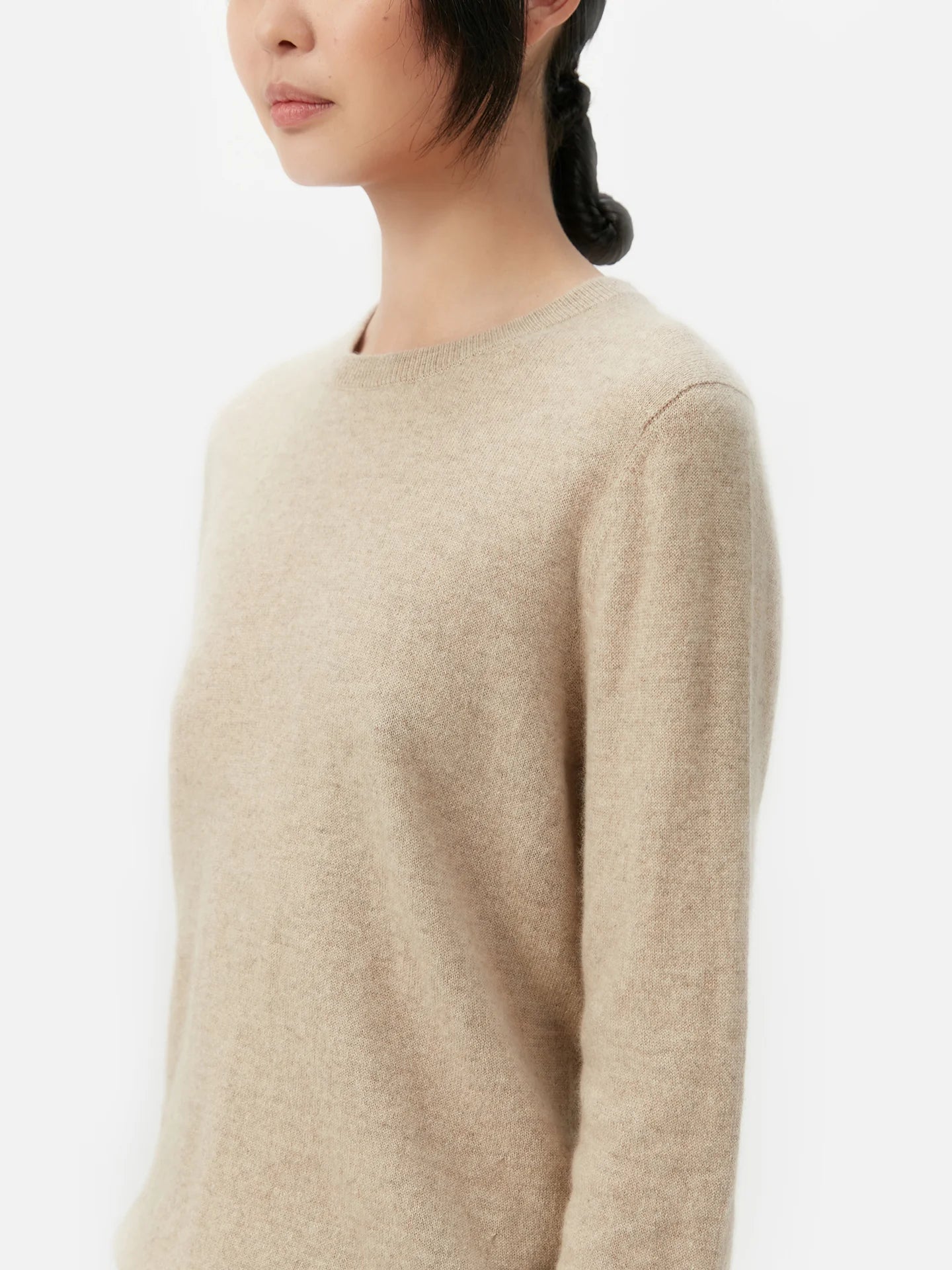 Beige sweater worn by a person on a white background